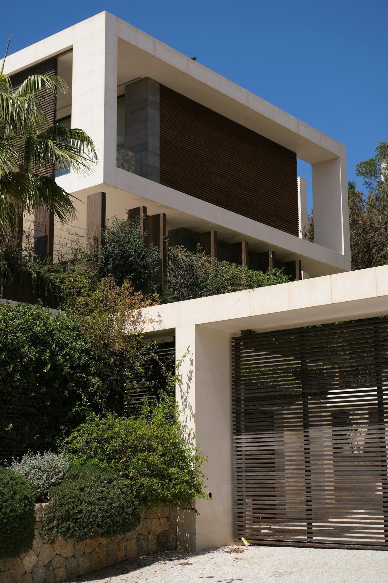 A white pavilion facade above planting